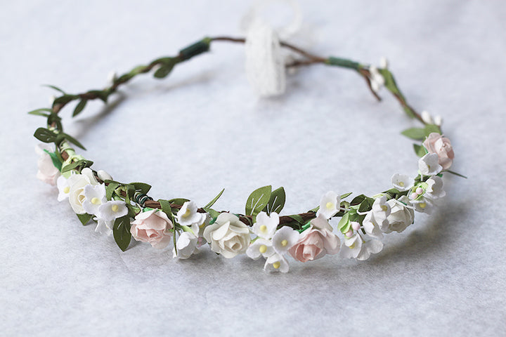 Couronne de fleurs artificielles blanche et rose pâle pour petites filles à porter pour accessoiriser une robe de cérémonie pour enfant et sublimer une coiffure.