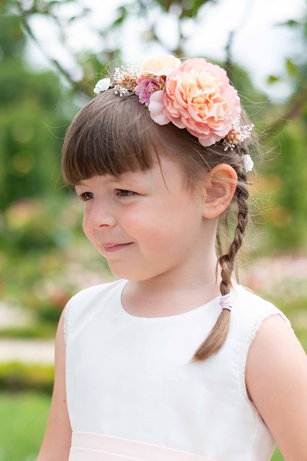 Couronne de fleurs artificielles avec fleurs roses et jaune pâle à porter avec une robe de cérémonie pour enfants. Parfait pour sublimer une coiffure de petite fille. Photo de la couronne portée par une petite fille.