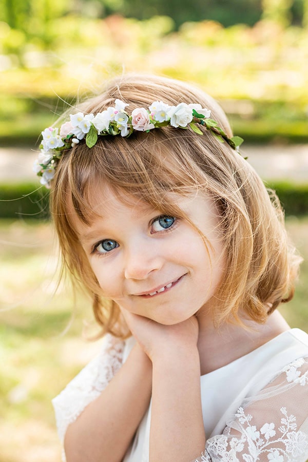 Couronne de fleurs artificielles blanche et rose pâle pour petites filles à porter pour accessoiriser une robe de cérémonie pour enfant et sublimer une coiffure.