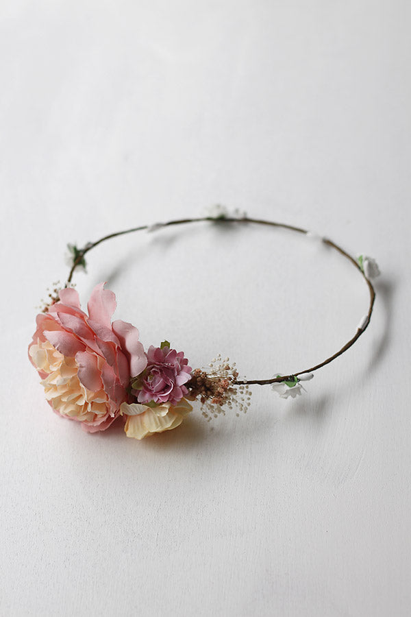 Couronne de fleurs artificielles asymétrique avec fleurs roses et jaune pâle à porter avec une robe de cérémonie pour enfants. Parfait pour sublimer une coiffure de petite fille. Boutique Fil de Légende à Paris, Neuilly-sur-Seine.