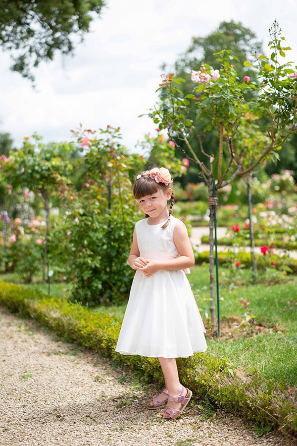 Couronne de fleurs artificielles avec fleurs roses et jaune pâle à porter avec une robe de cérémonie pour enfants. Parfait pour sublimer une coiffure de petite fille. Photo de la couronne portée vue de loin.