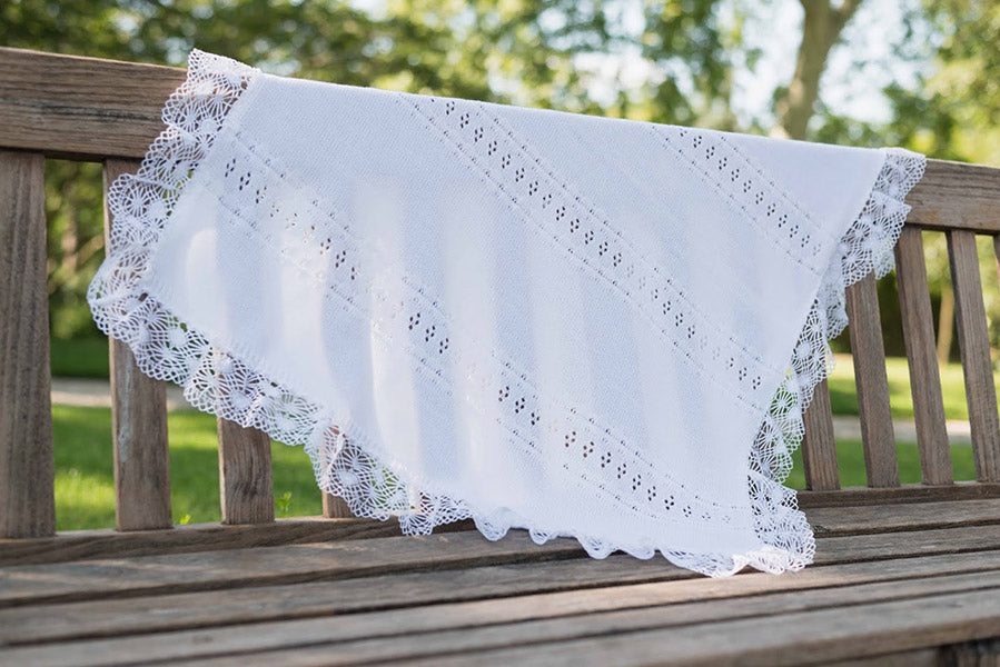 Couverture tricotée pour bébé en coton ajouré, bordée d'un large galon de dentelle de coton. Idéal pour baptême. Boutique Fil de Légende à Paris, Neuilly-sur-Seine.