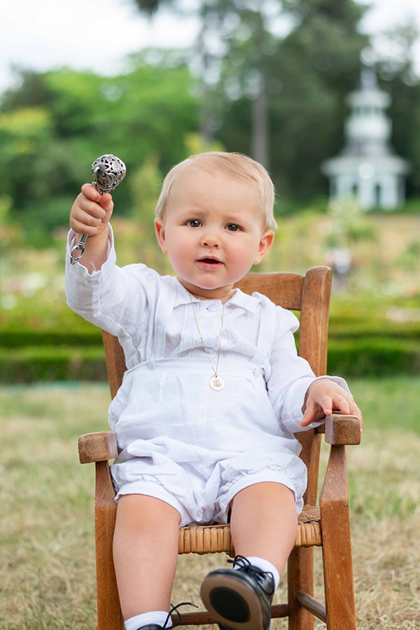 Ensemble baptême bébé garçon Alexandre avec chemise et salopette en lin blanc et dentelle de coton. Création française Fil de Légende. Photo de l'ensemble porté par un bébé garçon.