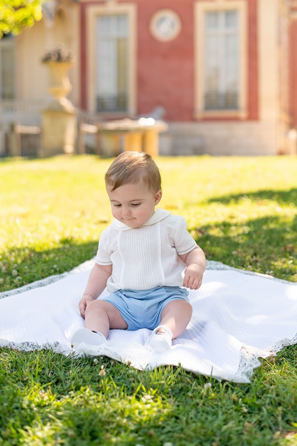 Ensemble cérémonie bébé garçon avec chemise de cérémonie manches courtes blanches et short bleu ciel. Modèle Clément, Fil de Légende. Photo de l'ensemble cérémonie bébé porté par un bébé garçon dans un parc.