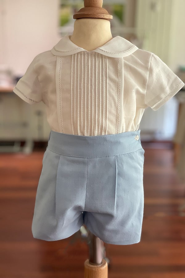 Ensemble cérémonie bébé garçon avec chemise de cérémonie manches courtes blanches et short bleu ciel. Modèle Clément, Fil de Légende. Disponible en ligne et en boutique à Paris, Neuilly-sur-Seine.