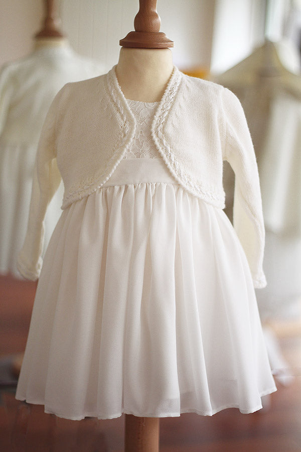 Gilet boléro pour bébé fille en laine blanc cassé. A porter avec une robe de cérémonie bébé. Boutique Fil de Légende à Paris, Neuilly-sur-Seine.