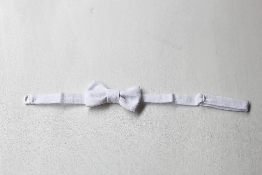 Nœud papillon pour bébé garçon en lin blanc. Idéal pour baptême ou cérémonie. Photo du nœud papillon à plat.