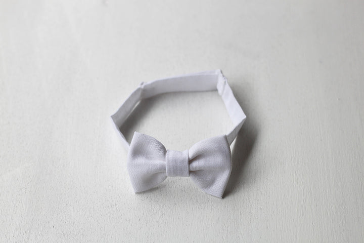 Nœud papillon pour bébé garçon en lin blanc. Idéal pour baptême ou cérémonie. Photo du nœud papillon en gros plan.