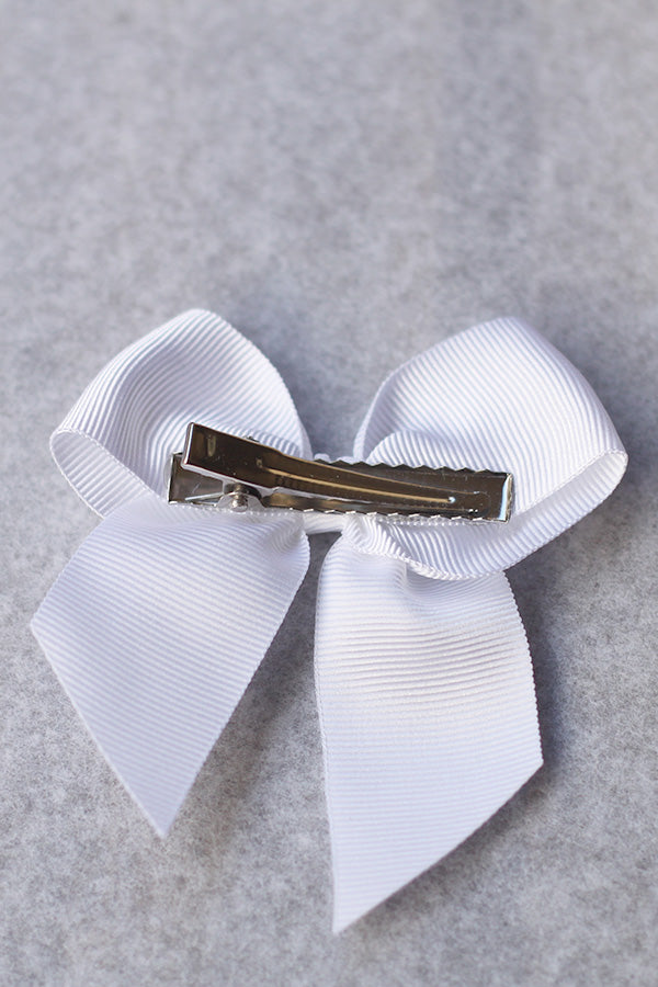 Pince cheveux noeud en gros grain blanc pour petite fille. Parfait pour sublimer une robe de cérémonie pour enfant. Photo du dos de la barrette.