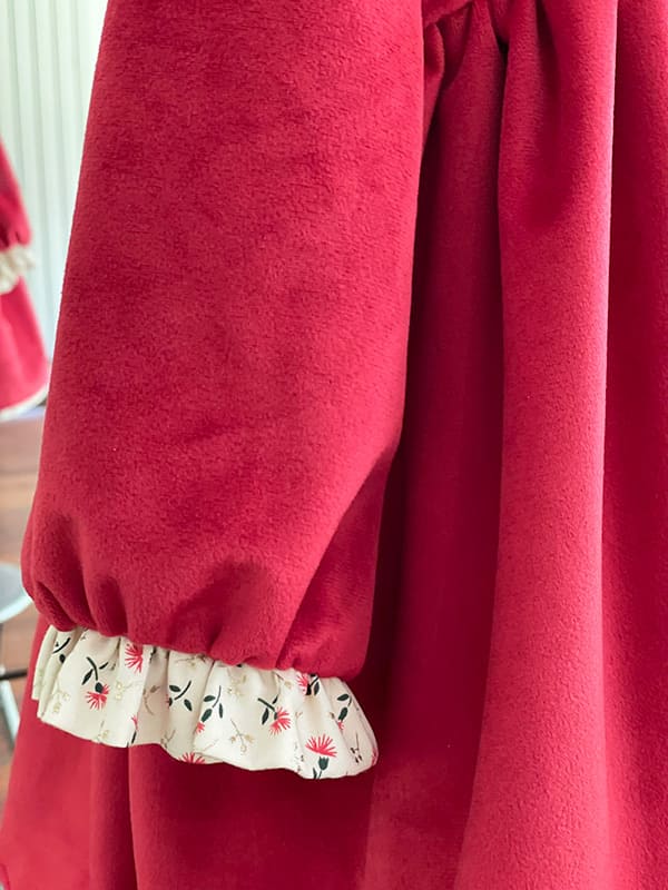 Robe de fête et cérémonie pour petite fille en tissu broché rose et or de fabrication française. Photo des manches.