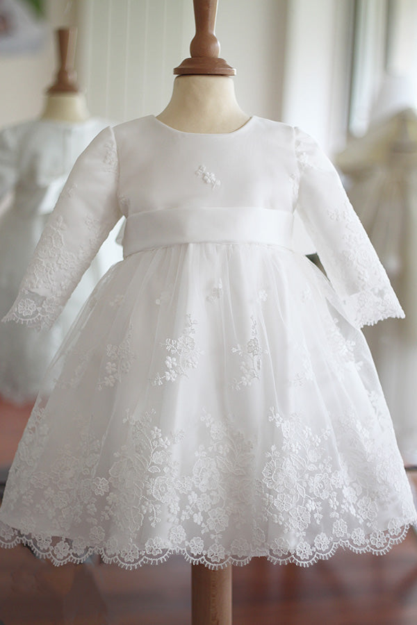 Robe de baptême et de cérémonie pour bébé et petite fille, en tulle brodé blanc cassé doublé de satin. Robe automne-hiver manches longues. Création française Fil de Légende. Disponible en ligne ou en boutique showroom à Paris, Neuilly-sur-Seine.