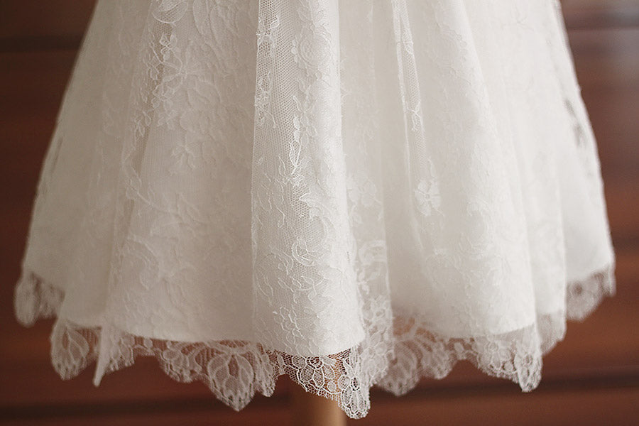 Robe de baptême fille en dentelle fine avec manches, corsage et jupe en dentelle. Cousu main en France. Photo de la dentelle de la jupe.