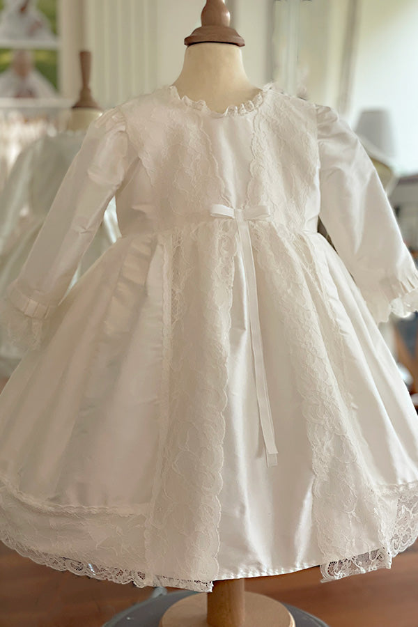 Robe de baptême fille en soie blanc cassé et dentelle dans un style princesse. Cousu main en France. Photo de la robe vue de côté.