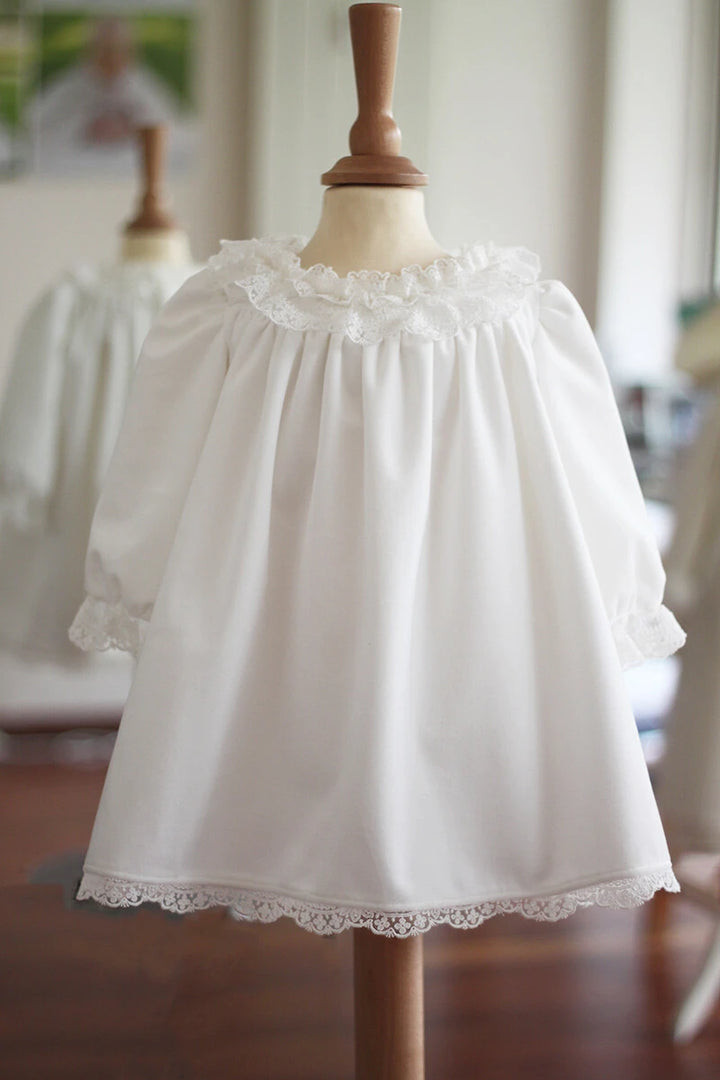 Robe de baptême fille pour l'hiver en velours blanc cassé et dentelle, doublée polaire. Création française Fil de Légende. Disponible en ligne et en boutique showroom Paris, Neuilly-sur-Seine.