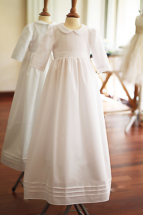 Robe traditionnelle mixte en coton blanc pour bébé fille et garçon. Corsage en coton brodé et dentelle de coton. Modèle manches longues. Création française Fil de Légende. Disponible en ligne ou en boutique showroom à Paris, Neuilly-sur-Seine.