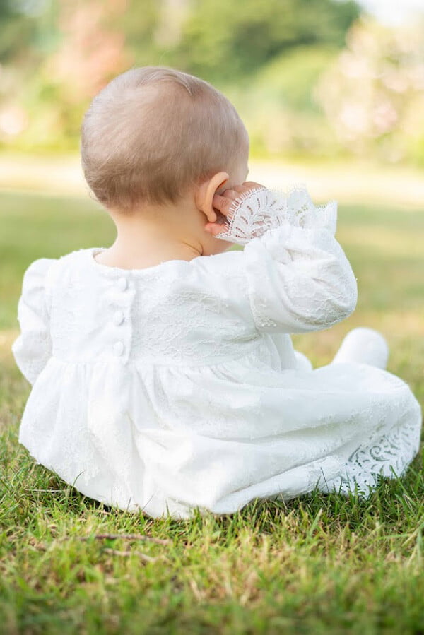 Robe de baptême ou de cérémonie pour bébé et petite fille en dentelle italienne, doublée de coton, modèle printemps à manches longues. Création Fil de Légende. Robe vue de dos.