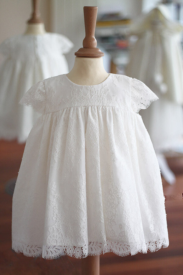 Robe de baptême ou de cérémonie pour bébé et petite fille en dentelle italienne, doublée de coton, modèle été à manches courtes. Création Fil de Légende. Photo de la robe sur mannequin de couture. 