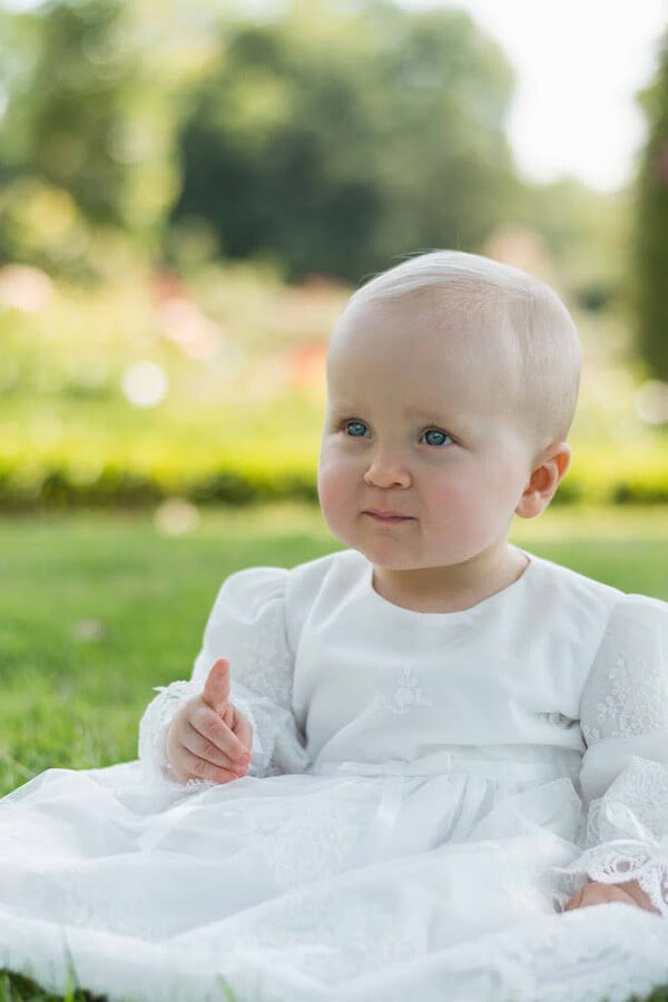 Robe de baptême pour bébé et petite fille en tulle brodé italien, doublée de coton, modèle printemps à manches longues. Création Fil de Légende. Photo de la robe portée par bébé.