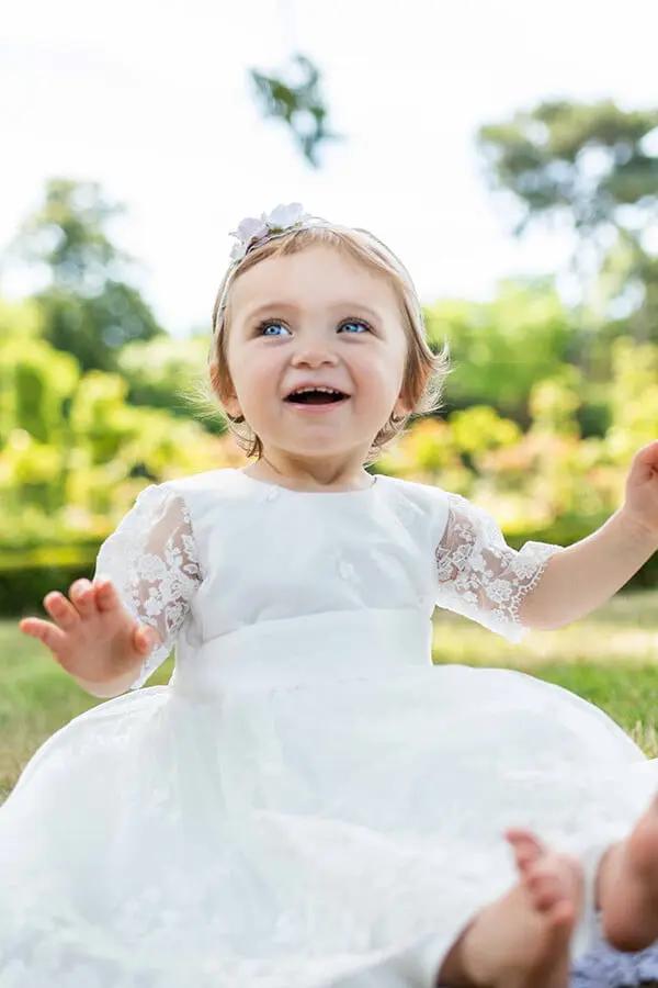Robe de baptême fille et tenue de cérémonie pour bébé en tulle brodé italien, doublée satin. Création française Fil de Légende, confection haut de gamme. Robe portée par un bébé fille.