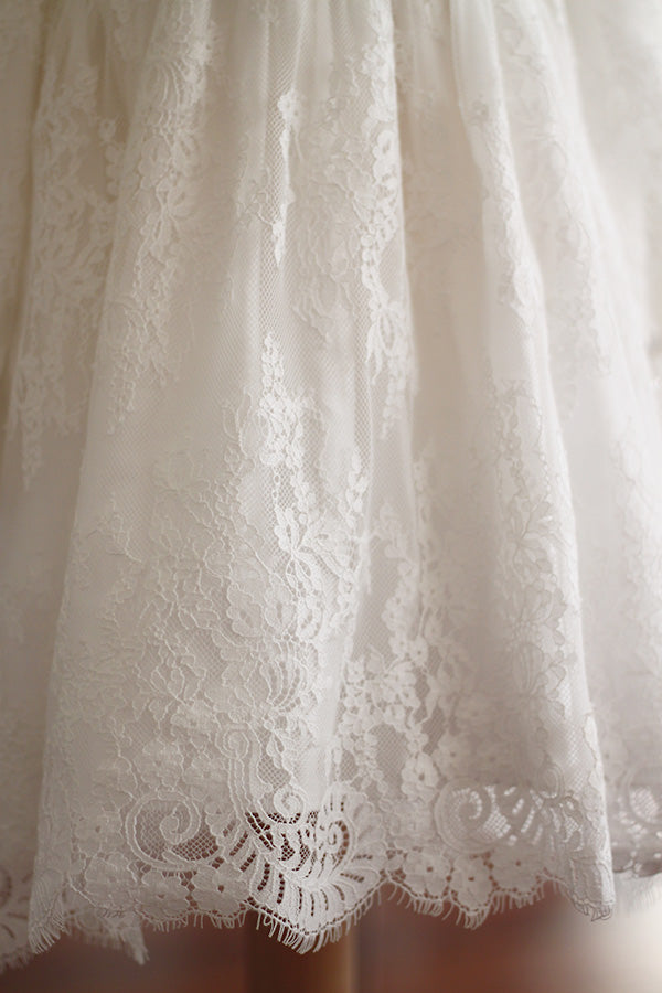 Robe de baptême fille taille haute en dentelle italienne blanc cassé doublée polaire. Modèle chaud pour l'hiver avec manches longues. Création française Fil de Légende. Photo de la jupe.