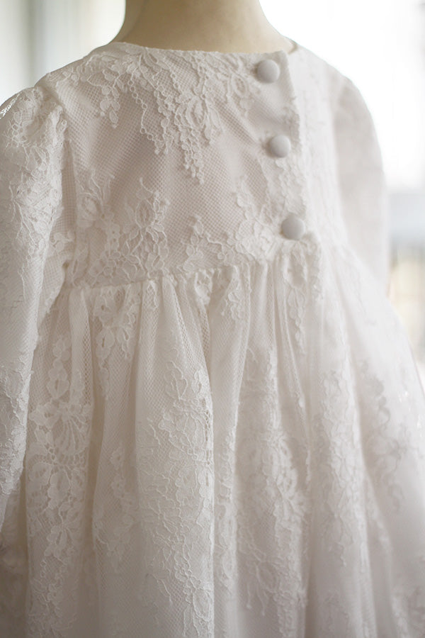 Robe de baptême fille taille haute en dentelle italienne blanc cassé doublée polaire. Modèle chaud pour l'hiver avec manches longues. Création française Fil de Légende. Photo du dos de la robe.