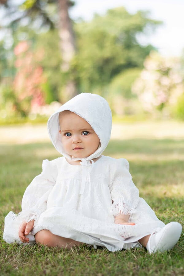Robe de baptême ou de cérémonie pour bébé et petite fille en dentelle italienne, doublée de coton, modèle printemps à manches longues. Création Fil de Légende. Photo de la robe portée par bébé.