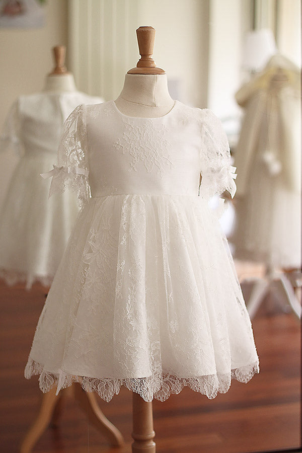 Robe de baptême fille en dentelle fine avec manches, corsage et jupe en dentelle. Cousu main en France. Boutique Fil de Légende à Paris, Neuilly-sur-Seine.
