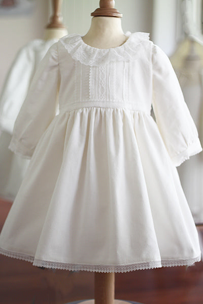Robe de baptême fille pour l'hiver en velours blanc cassé et dentelle de Calais, doublée polaire. Création française Fil de Légende. Disponible en ligne et en boutique showroom à Paris, Neuilly-sur-Seine.