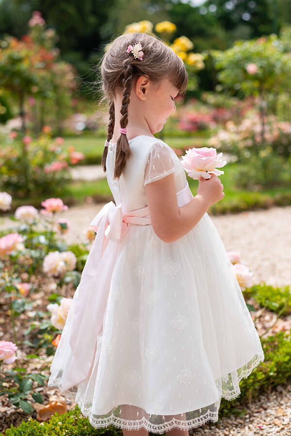 Robe de baptême ou de cérémonie pour bébé et petite fille en dentelle de Calais, doublée de satin, modèle été à manches courtes. Création Fil de Légende. Photo de robe portée par une petite fille.