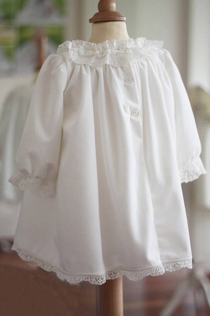 Robe de baptême fille pour l'hiver en velours blanc cassé et dentelle, doublée polaire. Création française Fil de Légende. Photo de la robe vue de dos.