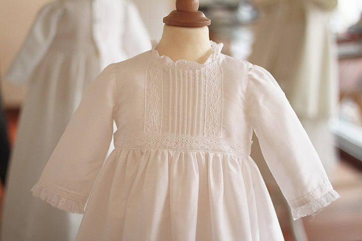 Robe baptême traditionnelle mixte pour bébé fille ou garçon en coton blanc et dentelle de Calais. Modèle manches longues. Création française Fil de Légende. Photo du corsage sur mannequin de couture.