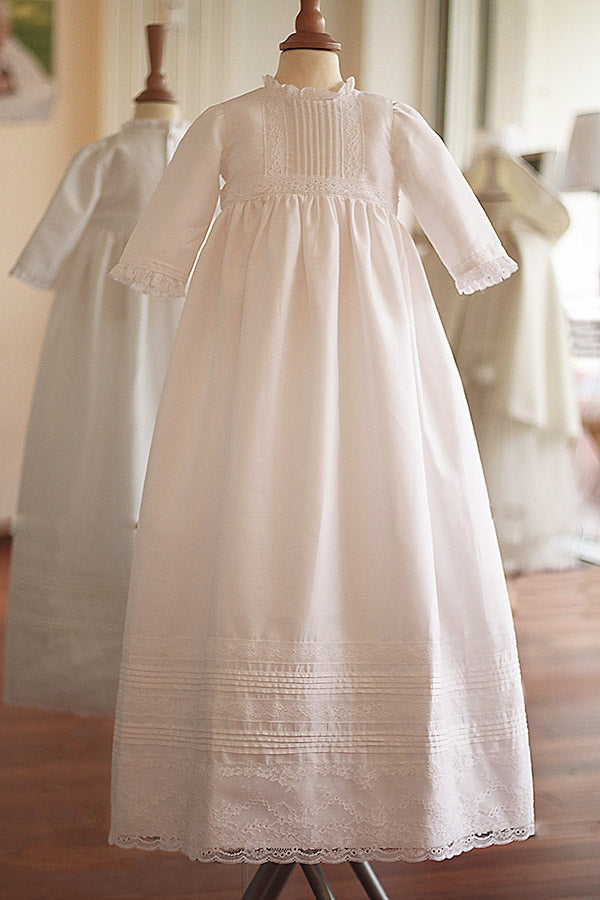Robe baptême traditionnelle mixte pour bébé fille ou garçon en coton blanc et dentelle de Calais. Modèle manches longues. Création française Fil de Légende. Disponible en ligne ou en boutique showroom à Paris, Neuilly-sur-Seine.