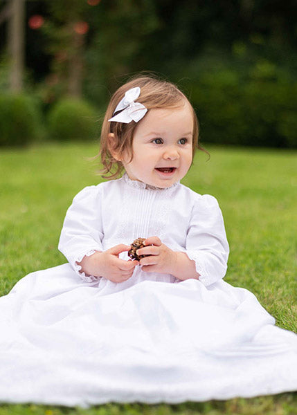 Pince cheveux noeud en gros grain blanc pour petite fille. Parfait pour sublimer une robe de cérémonie pour enfant. Photo de la barrette portée par un bébé fille.