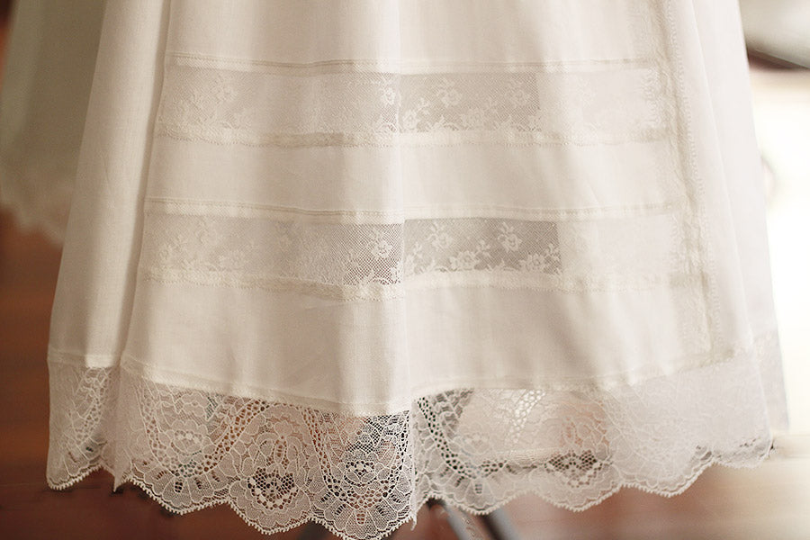Robe de baptême traditionnelle bébé en coton et dentelle de Calais blanc cassé. Modèle manches longues. Création française Fil de Légende. Photo du bas de la jupe.