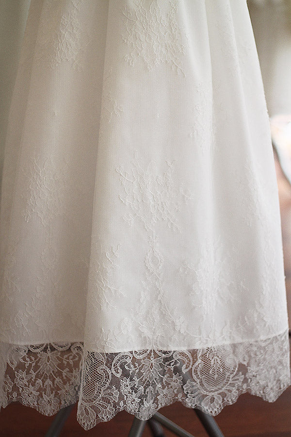 Robe de baptême traditionnelle bébé en dentelle fine de couleur blanc cassé. Corsage manches longues. Cousu main en France. Gros plan dentelle.