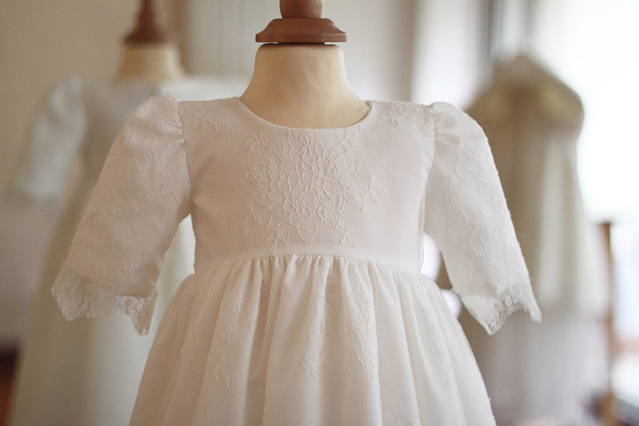 Robe de baptême traditionnelle bébé en dentelle fine de couleur blanc cassé. Corsage manches longues. Cousu main en France. Gros plan corsage.