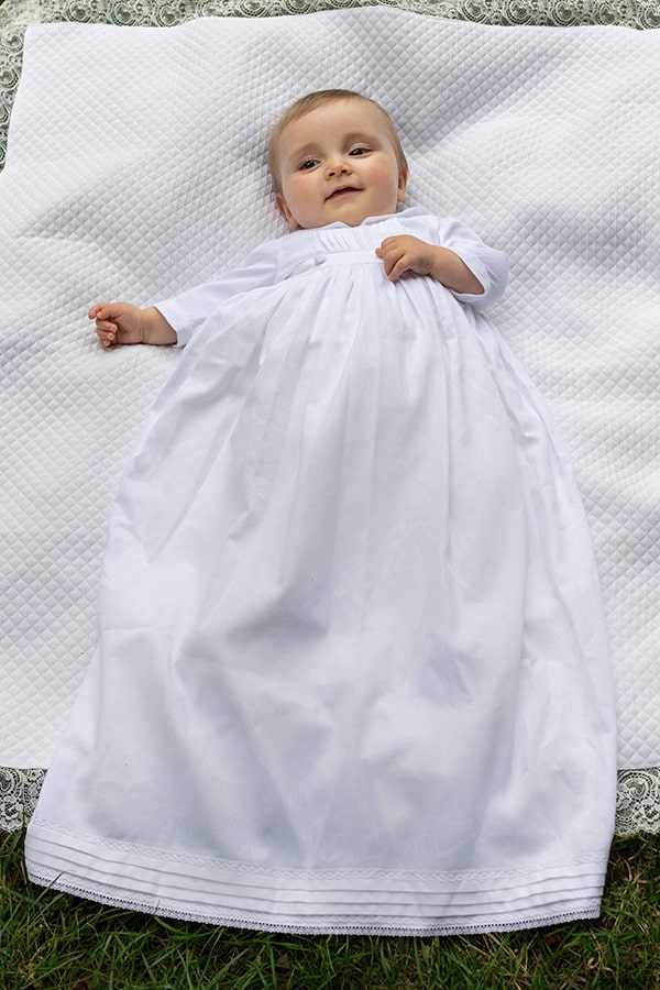 Robe de baptême traditionnelle bébé garçon Gabriel en piqué de coton blanc et dentelle de coton. Création française Fil de Légende. Photo de la robe portée par un bébé garçon.