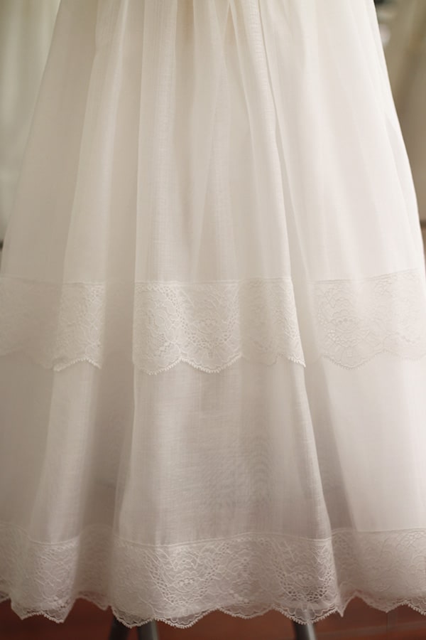 Robe de baptême longue traditionnelle mixte pour filles et garçons en mousseline et dentelle fine. Modèle manches longues. Création française Fil de Légende.  Photo de la jupe.