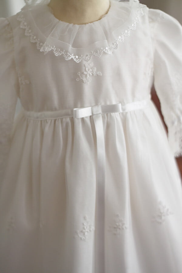 Robe de baptême traditionnelle bébé fille en tulle souple brodé et dentelle doublée coton. Création française Fil de Légende. Photo du noeud en satin.