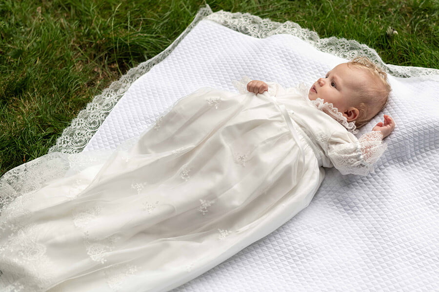 Robe de baptême traditionnelle bébé fille en tulle souple brodé et dentelle doublée coton. Création française Fil de Légende. Photo de la robe portée par bébé.