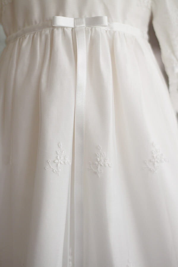 Robe de baptême traditionnelle bébé fille en tulle souple brodé et dentelle doublée coton. Création française Fil de Légende. Photo des motifs de la jupe.