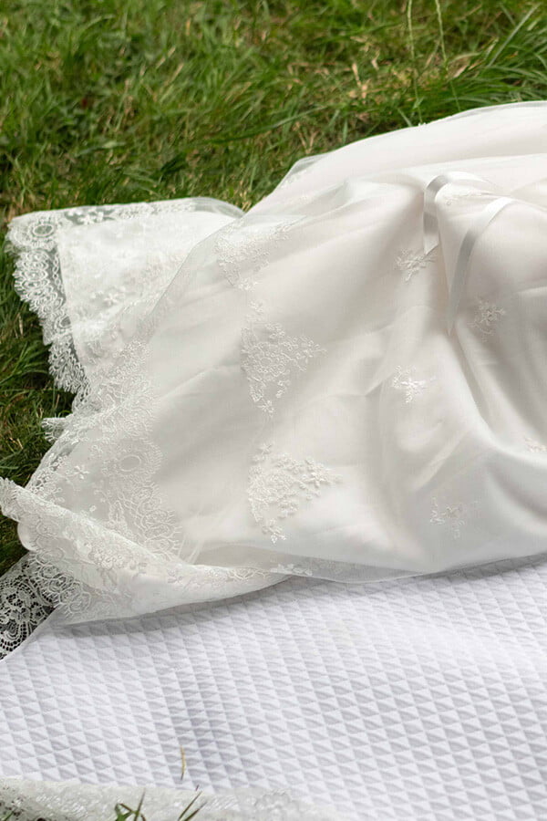 Robe de baptême traditionnelle bébé fille en tulle souple brodé et dentelle doublée coton. Création française Fil de Légende. Photo de la jupe.