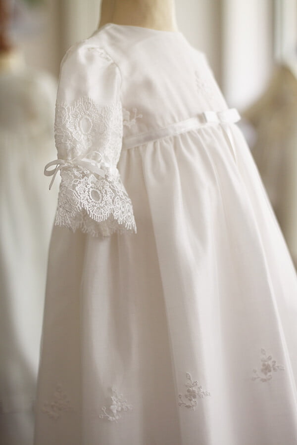Robe de baptême traditionnelle bébé fille en tulle souple brodé italien et dentelle doublée coton. Modèle manches longues. Création française Fil de Légende.  Photo du côté de la robe.