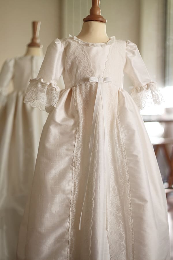 Robe de baptême traditionnelle bébé fille en soie et dentelle dans un style princesse. Cousu main en France. Photo de la robe sur mannequin de couture.