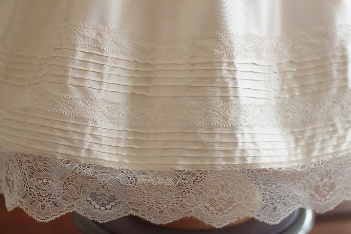 Robe de baptême et brit milah en soie française et dentelle. Cousu main en France. Photo du détail des petits plis sur le bas de la jupe.