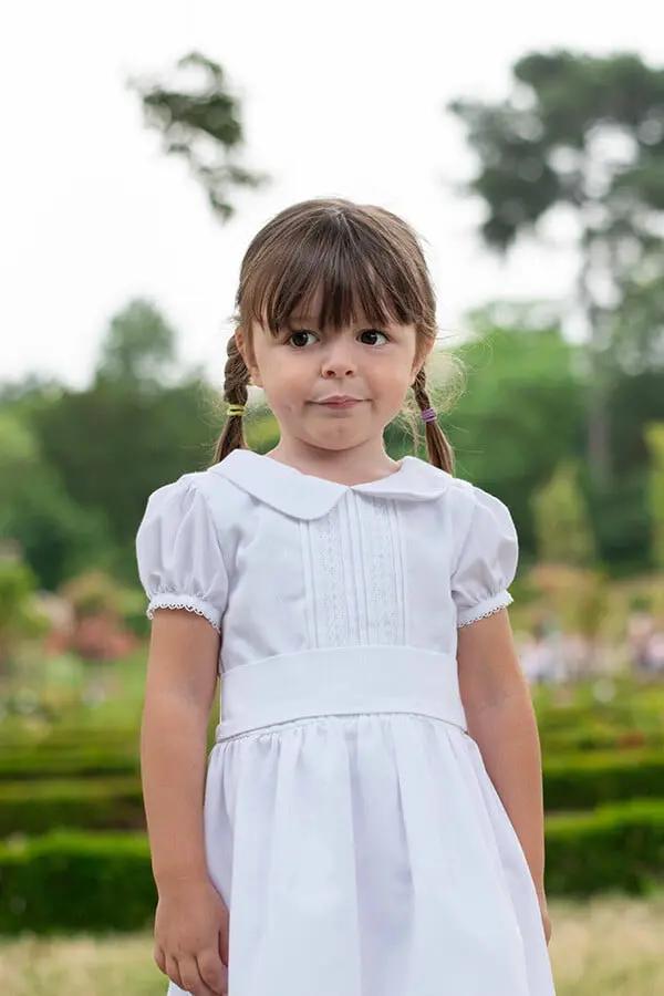 Robe de baptême et de cérémonie pour bébé et petite fille, en piqué de coton blanc et dentelle de coton. Ceinture au choix blanche ou rose. Création française Fil de Légende. Photo du corsage.