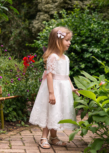 Pince cheveux noeud en gros grain de couleur vieux rose. Parfait pour sublimer une coiffure de petite fille à l'occasion d'une cérémonie. Photo de la barrette portée avec une robe de cérémonie.