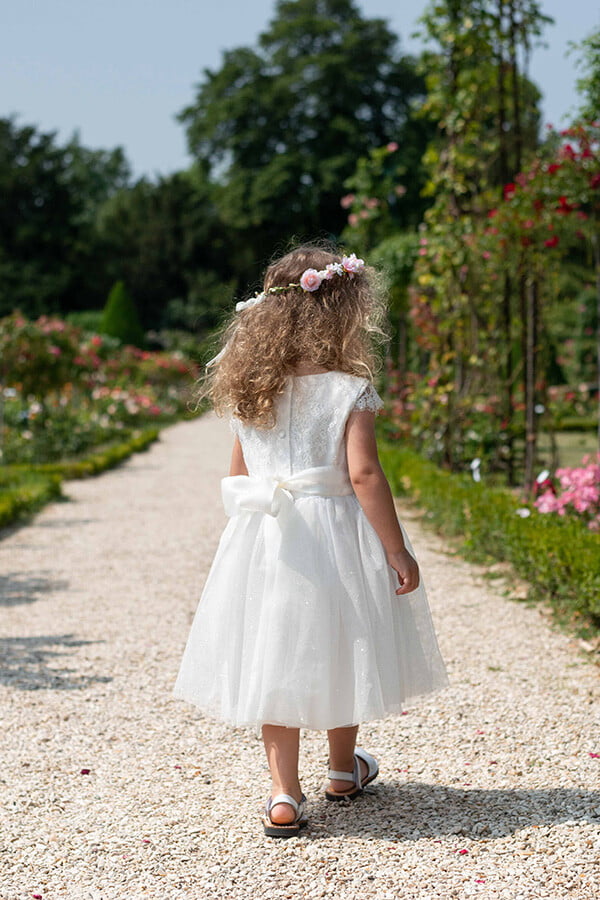 Robe de baptême et de cérémonie pour bébé fille, corsage en dentelle italienne blanc cassé, jupe en tulle pailleté, ceinture en soie. Robe de baptême haut de gamme, création française Fil de Légende. Photo de la robe vue de dos.