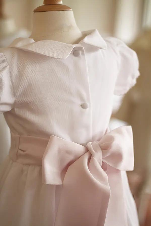Robe de baptême et de cérémonie pour bébé et petite fille, en piqué de coton blanc et dentelle de coton. Ceinture au choix blanche ou rose. Création française Fil de Légende. Photo de la ceinture rose.
