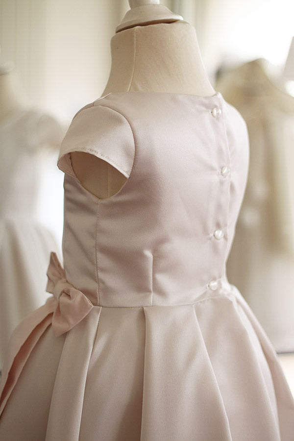 Robe longue de cérémonie fille en satin crème et noeud rose. Cousu main en France. Vue de dos.